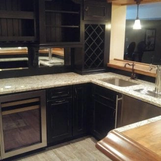 Porcelain floor installation with black rusted cabinets and wood with granite top bar combination in Baltimore