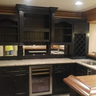 basement-bar-installation-with-black-rusted-look-cabinets